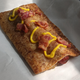 Apple Pie Hot Dog sitting in sunbeam on parchment paper